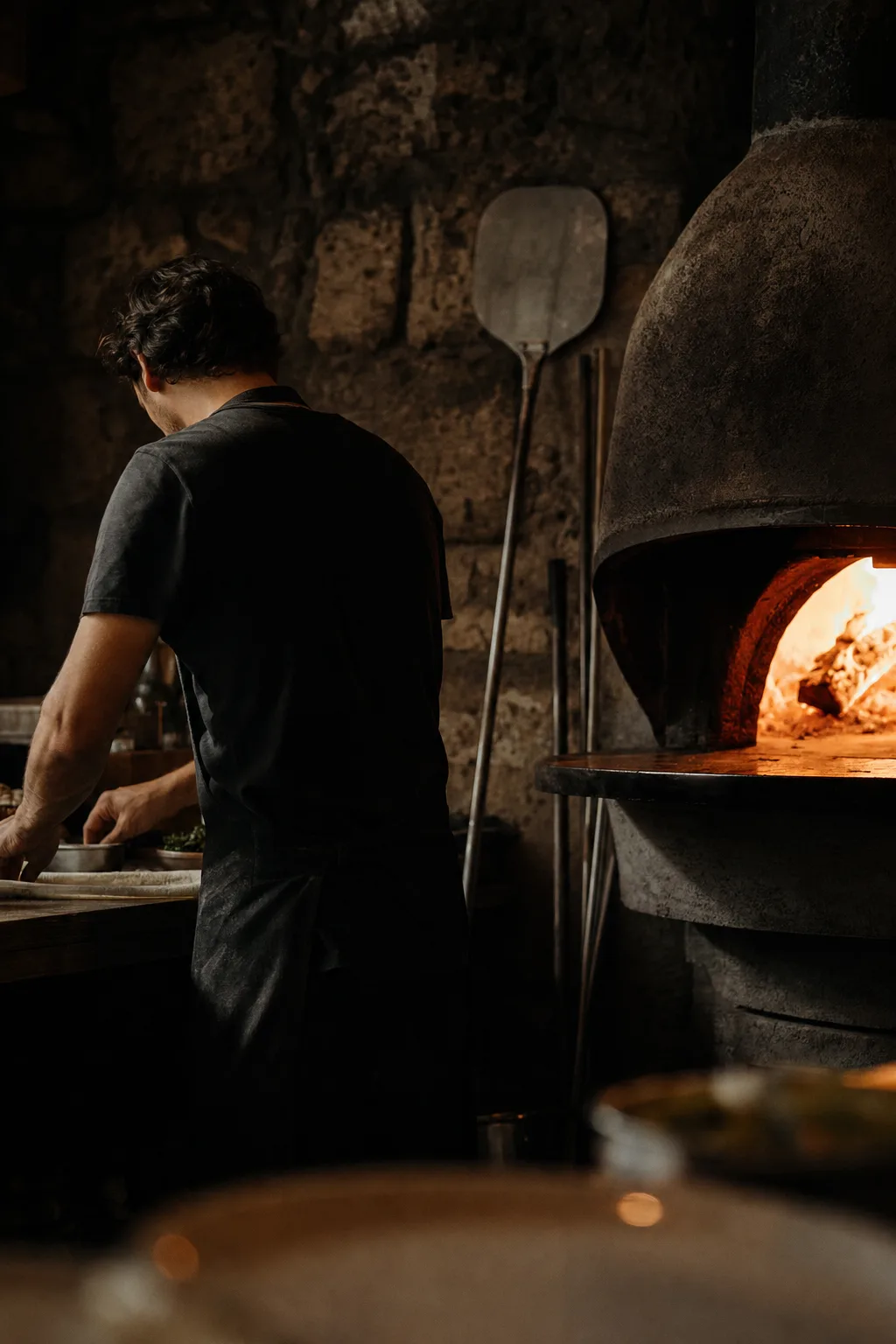 Le chef devant le four à bois